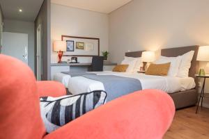 a hotel room with two beds and a television at B The Guest Downtown in Porto