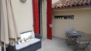 patio con tavolo, sedia e porta rossa di B&B ForseSiForseNo a Sulzano
