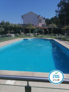 une grande piscine d'eau bleue dans l'établissement Quintinha dos Queiroses, à Vila Boa de Quires