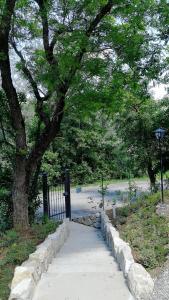 Una pasarela en un parque con un árbol y una valla en Parco di Montebello, en Quattro Castella