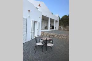 eine Terrasse mit einem Tisch und Stühlen neben einem Gebäude in der Unterkunft Luxury & Charme fronte mare Sardinia House 5 in Carloforte