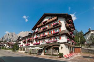 a building with balconies on the side of a street at Hotel Trieste in Cortina dʼAmpezzo