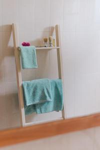 a bathroom with two green towels on a shelf at Paje White House Boutique Hotel in Paje