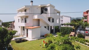 a white house with a lawn in front of it at Apartments Radosevic in Ulcinj