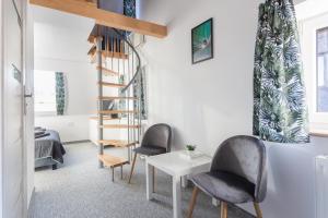 a living room with two chairs and a spiral staircase at VILLA TO-TU in Szklarska Poręba