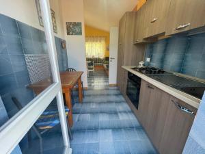 a kitchen with blue tiles on the floor and a table at Villa Venere al Sauce - esclusiva villa sul mare in San Vito lo Capo