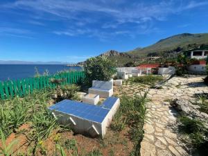 a bench with a view of the ocean at Villa Venere al Sauce - esclusiva villa sul mare in San Vito lo Capo +34 photos