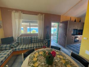 a living room with a table and a couch at Villa Venere al Sauce - esclusiva villa sul mare in San Vito lo Capo