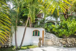 Biały dom z palmami przed nim w obiekcie Villa Bruga en Samara Rocks w mieście Sámara