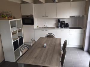 een keuken met een houten tafel en stoelen. bij Vissershuisjes Wenduine-De Haan in Wenduine