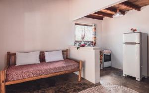 a small kitchen with a bench and a refrigerator at Vila Piê in Itacaré