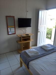a bedroom with a bed and a tv and a mirror at Pousada Atlantico Centro - Fortaleza in Fortaleza