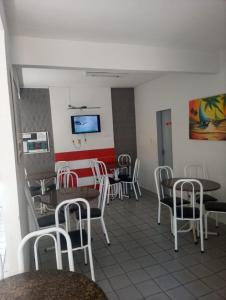 une salle à manger avec des chaises, des tables et une télévision dans l'établissement Pousada Atlantico Centro - Fortaleza, à Fortaleza