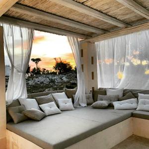 a couch sitting in a room with windows at Tenuta Trullo Padronale-Private Pool Exclusive Villa Ostuni in Ostuni
