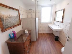uma casa de banho com um lavatório, um chuveiro e um espelho. em 60qm 2 Raum Wohnung nahe dem Stadtzentrum em Rostock