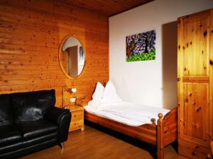 a bedroom with a bed and a black leather chair at Stadl Suite in Sankt Margarethen im Lavanttal