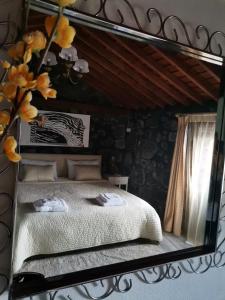 espejo que refleja una cama en una habitación en Casinha de Pedra, en Cais do Pico