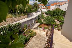 Blick auf den Garten vom Balkon eines Hauses in der Unterkunft Apartments Zvone - Apartments with terrace in Supetar