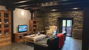 a living room with a couch and a tv at El Balcón de Sotillo - Las Médulas - Senderismo por Canales Romanos in Sotillo de Cabrera