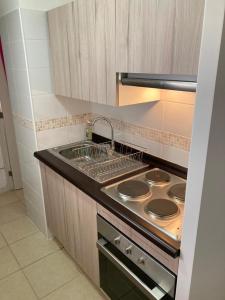 eine Küche mit Herd und Spüle in der Unterkunft BONITO DEPARTAMENTO A METROS DE AVENIDA DEL MAR in La Serena + 16 Fotos