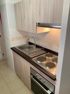 a kitchen with a stove and a sink in it at BONITO DEPARTAMENTO A METROS DE AVENIDA DEL MAR in La Serena