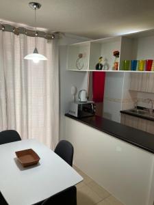 a kitchen with a table and a white counter top at BONITO DEPARTAMENTO A METROS DE AVENIDA DEL MAR in La Serena