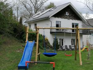 une aire de jeux avec balançoires en face d'une maison dans l'établissement An der Mühle, à Galhausen