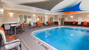 a pool in a hotel room with chairs and a table at Best Western Muscatine - Pearl City Hotel in Muscatine