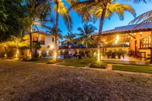 uma casa com palmeiras em frente em Sombra do Coqueiro Villas - 150m da Praia em Luis Correia