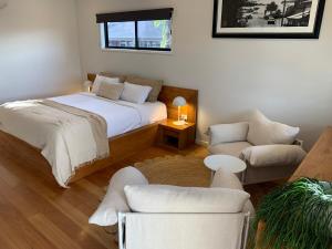 a bedroom with a bed and a couch at Aabi's at Byron in Byron Bay