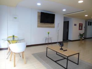 a living room with a tv and a table and a chair at Hotel paradise del cafe in Pereira