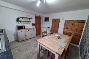 uma cozinha com uma mesa de madeira num quarto em North Coast Property - North Coast Cottage em Thurso