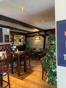 a restaurant with wooden tables and chairs and a brick wall at Old Aberlady Inn in Aberlady