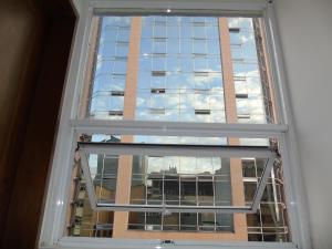 a window with a view of a building at Hotel Paradise del Cafe in Pereira