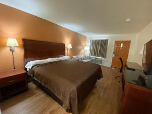 ein Hotelzimmer mit einem großen Bett und einem TV in der Unterkunft KINGS INN in LaFayette