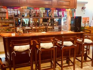 um bar com quatro cadeiras e um balcão com garrafas em Hotel Boutique La Herencia em Tequisquiapan