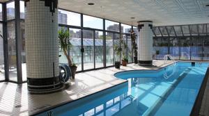 a swimming pool in a building with windows at Your Vacation Home Downtown Vancouver in Vancouver