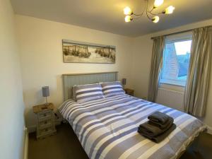a bedroom with a bed with a suitcase on it at Penthouse Waterfront Apartment - St Neots in Saint Neots