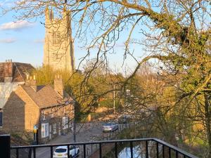 a view of a building with a tower and a street at Penthouse Waterfront Apartment - St Neots in Saint Neots