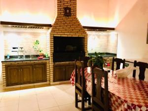 a kitchen with a table and a brick fireplace at La Esperanza in Piribebuy