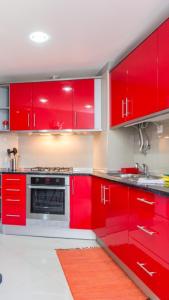 - une cuisine rouge avec des placards rouges et un évier dans l'établissement T3 Alex,moderno iluminado e amplo,excelente local, à Portimão