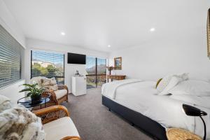 um quarto com uma cama, uma cadeira e uma janela em Balmoral Lodge em Queenstown