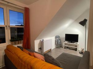 sala de estar con sofá y TV en Carvetii - Edward House D - 2 Dbl bed 2nd floor flat, en Dunfermline