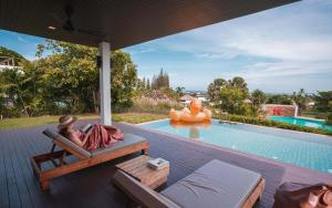 a woman laying in a chair next to a swimming pool at The Spirit Resort Hua Hin in Khao Tao