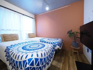 a bedroom with a bed with a blue and white comforter at Luana Shibuya in Tokyo