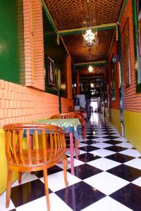 a restaurant with tables and chairs on a checkered floor at Kampoeng Djawa Hotel in Yogyakarta