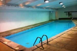 a large swimming pool with blue water in a building at SKI In/Out Monteblanco El Colorado in Santiago