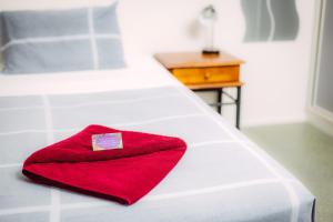 a red towel is sitting on a white bed at Tropical Lodge in Innisfail