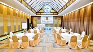 a conference room with tables and chairs and a screen at Smile Lanna Hotel in Chiang Mai