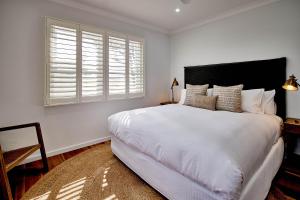 um quarto com uma grande cama branca e uma janela em Goonoo Goonoo Station em Tamworth